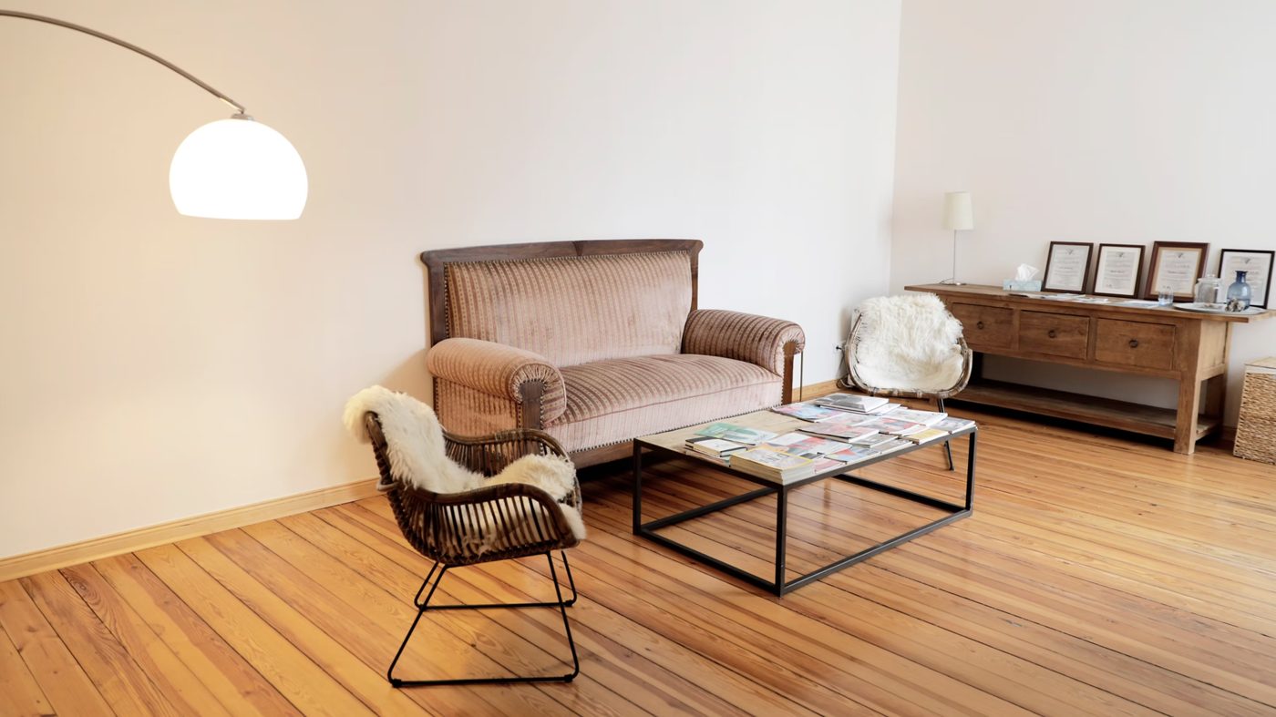 The practice room: a sofa, two armchairs and a low table on a wooden floor